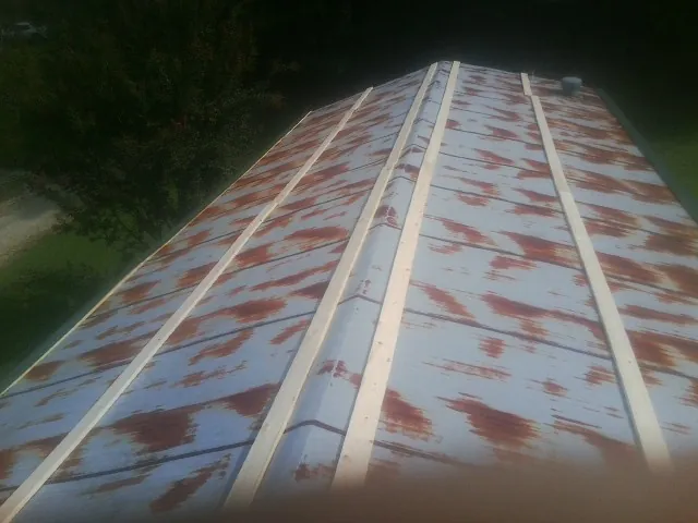 Rusted metal roof panels with new wood purlins before replacement — Storm Damage Roof Repair in Morganville by Roofing Brothers
