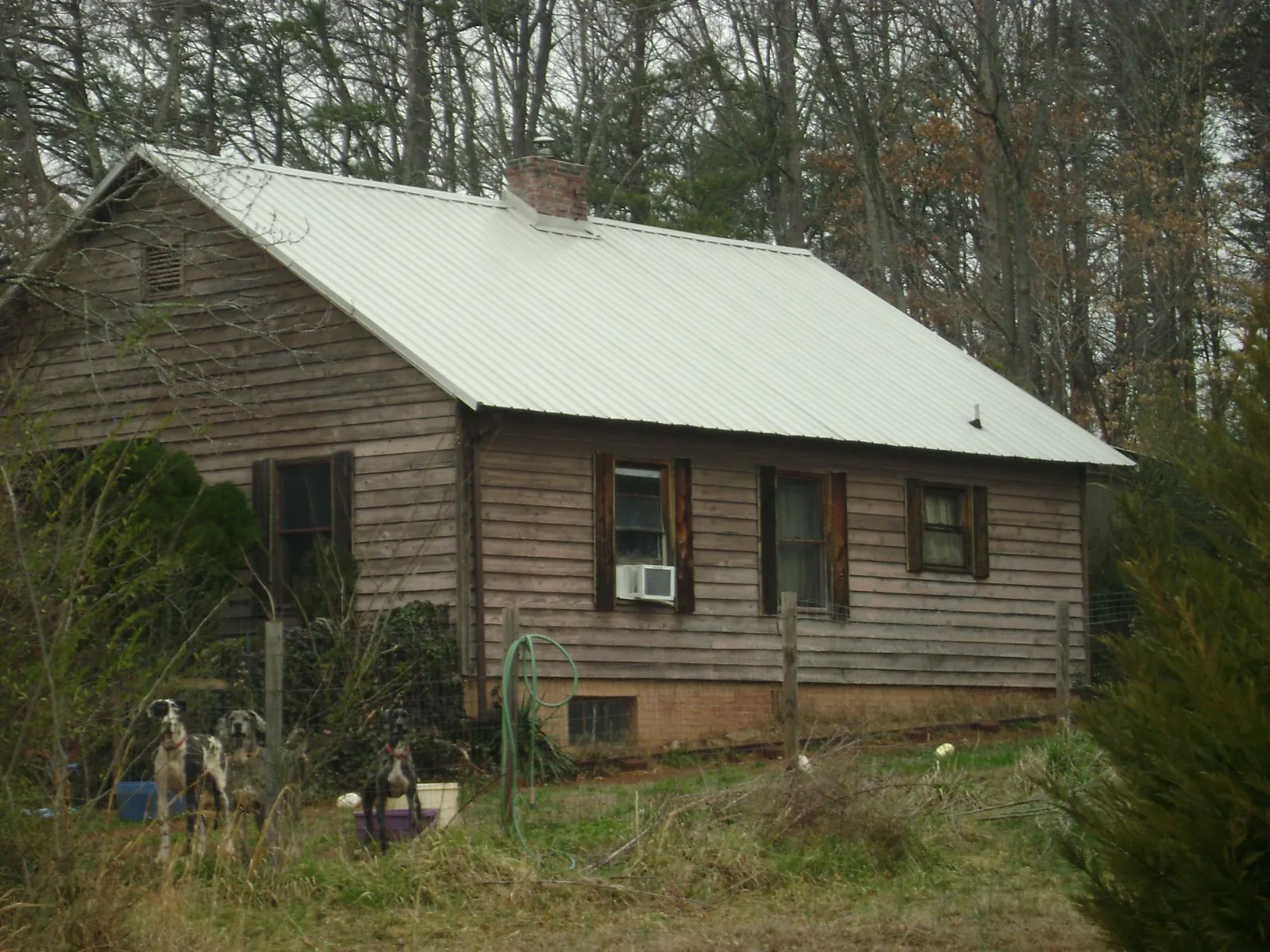 White metal roof on an old wood sided farmhouse, from a Metal Roof Installation job in Morganville